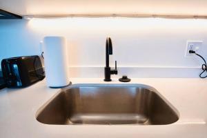 a kitchen counter with a sink and a roll of paper towels at The Downtown Lookout DT Gym free parking in Salt Lake City