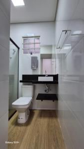 a bathroom with a toilet and a sink at Residencial Aurelio Souza Studios in Pouso Alegre +58 photos
