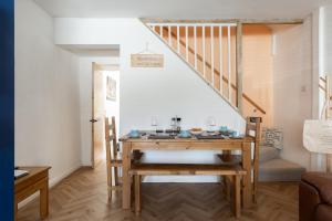 ein Esszimmer mit einem Tisch und einer Treppe in der Unterkunft 'Haworth Haven', Warm Winter Cottage Getaway in Haworth