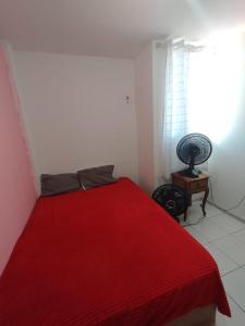 Cama roja en habitación blanca con ventana en quarto temporada são joão familiar até 4 pessoas, en Campina Grande 1 foto más