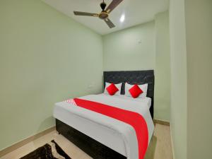 a bedroom with a large bed with red pillows at SPOT ON SRI DATTA GRAND INN in Warangal