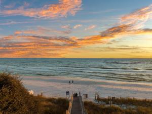una playa con un paseo marítimo de madera que conduce al océano en The Pointe Unit 122 by 30A Escapes, en Rosemary Beach