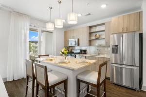 Una cocina con una mesa con sillas y un refrigerador. en The Pointe Unit 122 by 30A Escapes, en Rosemary Beach