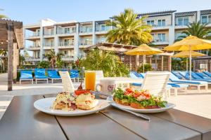 dos platos de comida en una mesa en un patio en The Pointe Unit 122 by 30A Escapes, en Rosemary Beach
