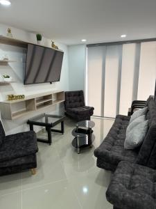 un salon avec deux canapés et une télévision à écran plat dans l'établissement 202 Nuevo Poblado y Provenza muy cerca, à Medellín