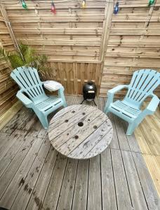 zwei Stühle und ein Tisch auf einem Holzdeck in der Unterkunft LoveRoom le moutik du bord de mer avec SPA et sauna parking gratuit in Lampaul-Plouarzel
