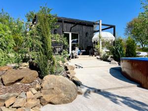 un edificio nero con rocce in un cortile di Garden Residence - The Nest a Drahobudice