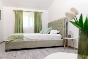SăfticaVarer的一间卧室配有一张带绿色窗帘的床
