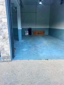 an empty room with blue floors and a room with a table at Villa Nova Bar in Zaljevo