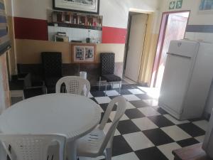 a kitchen with a white table and a white refrigerator at Valley Center Guest House in Johannesburg