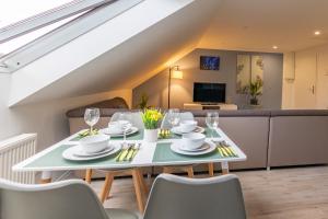a dining room and living room with a table and chairs at HANNIBAL - City Apartment "T-Roc", VW Nähe, Parkplatz, City Nähe, Küche, HighSpeed-WLAN in Wolfsburg