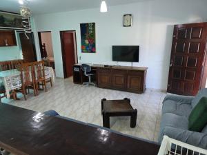 a living room with a couch and a tv at Recanto feliz in Peruíbe