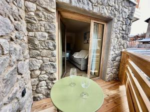 2 bicchieri da vino seduti su un tavolo sul balcone di Résidence Le Living Stone B - COCON A LA MONTAGNE, CENTRE VARS-Tout inclus MAE-7691 a Vars