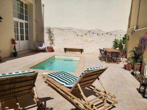 a patio with a pool and chairs and a table at Casa Ianca in Lecce