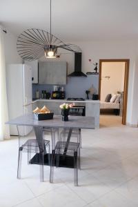 a kitchen with a table and chairs in a room at Adria Art Apartments 3 in Adria