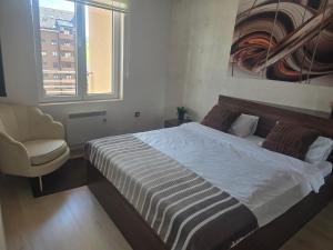 a bedroom with a bed and a chair and a window at Sunny view in Zlatibor