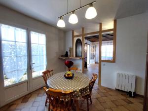 a dining room with a table and chairs and windows at Holiday Home Proche Océan- forêt et commerces by Interhome in Fromentine +17 photos