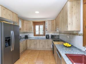 una cucina con mobili in legno e un frigorifero in acciaio inossidabile di Villa Hacienda Azahar by Interhome a Sant Jordi