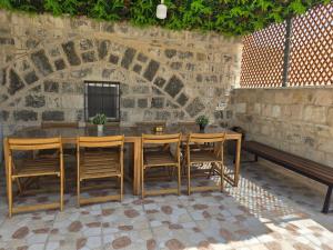 a wooden table and chairs and a bench in a patio at dar sharaf in Jerusalem