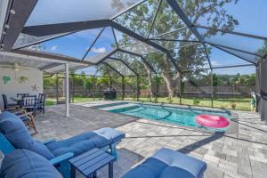 a patio with a swimming pool with a glassconservatory at Silver Palm Retreat in Sarasota