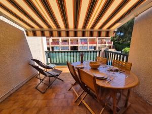 une table et des chaises en bois sur un balcon dans l'établissement Studio piscine, proche mer, parking privé, à Bandol