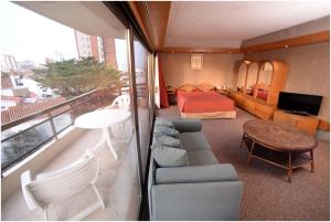 a room with a balcony with a bedroom and a bed at Hosteria Tequendama Classic & Resort in Villa Gesell