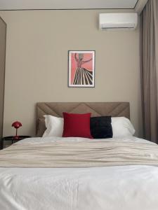 a bedroom with a white bed with a red pillow at Студия КАКАО рядом с Арбатом in Almaty