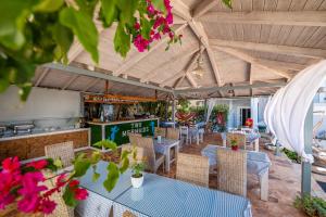 an outdoor restaurant with tables and chairs and flowers at Hotel Two Mermaids Ksamil in Ksamil