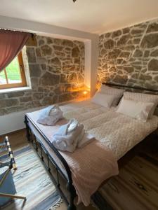 two beds in a room with a stone wall at Casa Tilia in Omar +58 photos