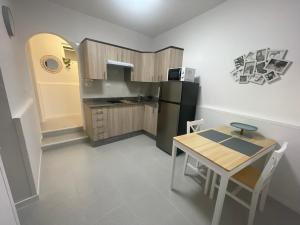 a small kitchen with a table and a black refrigerator at Casa Mar in Punta de Mujeres