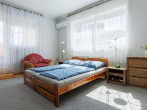 ein Schlafzimmer mit einem Bett und einem Stuhl in der Unterkunft Apartment Baum by Interhome in Fonyód + 24 Fotos