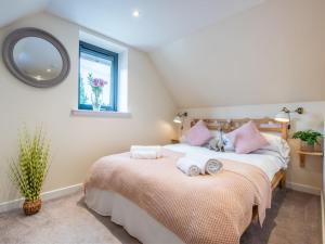 two beds in a bedroom with a mirror and a window at Apartment Wayside Loft by Interhome in Drumnadrochit