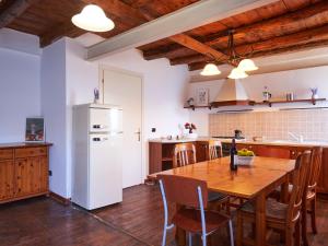 kuchnia z drewnianym stołem i białą lodówką w obiekcie Apartment Popa by Interhome w mieście Bellano