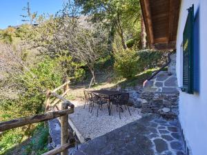 stół i krzesła na kamiennym patio w obiekcie Apartment Popa by Interhome w mieście Bellano