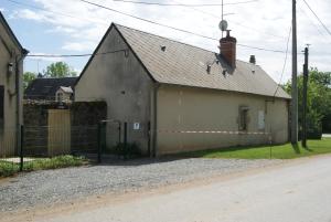 a large building with a fence next to a street at Gite de la Croix in Briantes