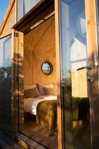 een kamer met een bed in een glazen deur bij Luxe Wikkelhouse met hottub 'Dompel' in Hoogwoud +32 foto's