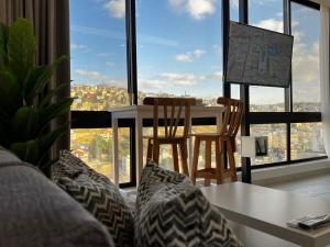 a living room with a table and chairs in front of a window at Brand new, Modern, Breathtaking view, just for you in Amman