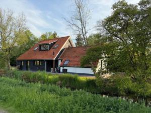 a large house with a red roof at De Geluksbrenger in Spanga