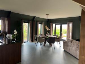 a kitchen and dining room with a table and chairs at De Geluksbrenger in Spanga