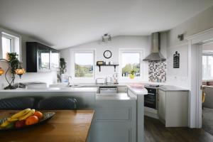 a white kitchen with a bowl of fruit on a table at River Shack in Doolin