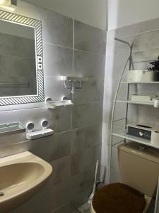 a bathroom with a sink and a mirror and a toilet at résidence Nathalia in Abidjan