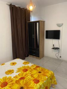 a bedroom with a bed with yellow flowers on it at résidence Nathalia in Abidjan +14 photos