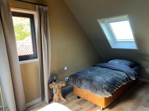 a bedroom with a bed and a window at De Geluksbrenger in Spanga
