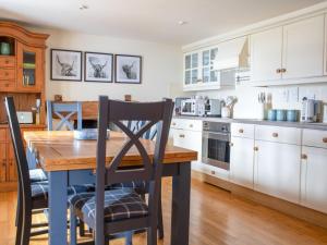 a kitchen with a wooden table and chairs at Holiday Home Skye Nadair by Interhome in Isleornsay
