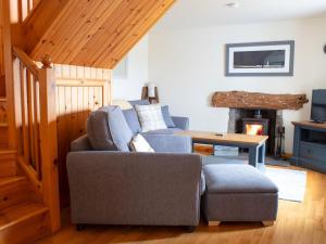 a living room with a couch and a fireplace at Holiday Home Skye Nadair by Interhome in Isleornsay