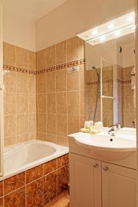 a bathroom with a tub and a sink and a bath tub at Logis Des Trois Maures in Couches