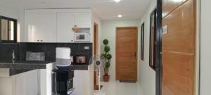 a kitchen with white cabinets and a coffee maker at The Camp Pad in San Roque