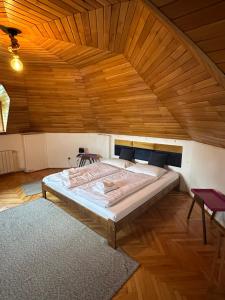 a large bed in a room with a wooden ceiling at Pine Peak in Predeal