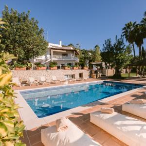 Una piscina con sillas y una casa al fondo. en Villa Bloom, en Nuestra Señora de Jesús