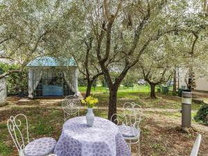 a table and chairs with a vase of flowers on it at Holiday Home Acquila by Interhome in Umag